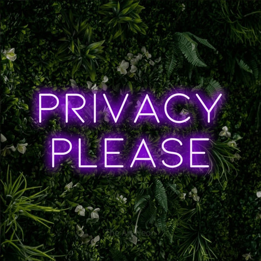 Purple LED neon sign reading "Privacy Please" against a leafy green wall for hotel décor