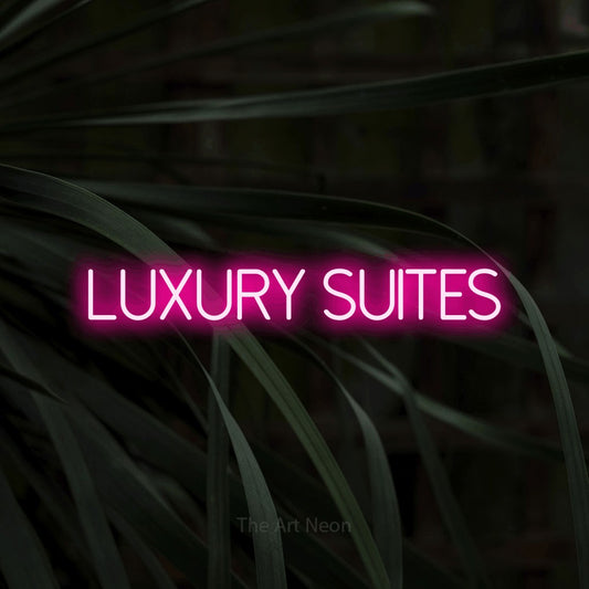Hot pink LED neon sign reading "Luxury Suites" against dark tropical leaves for hotel décor