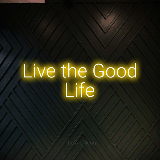 Yellow LED neon sign reading "Live the Good Life" against a dark geometric wood wall for hotel décor