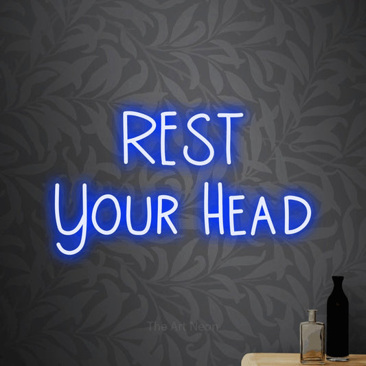 Blue LED neon sign reading "Rest Your Head" against light grey floral wallpaper for hotel décor