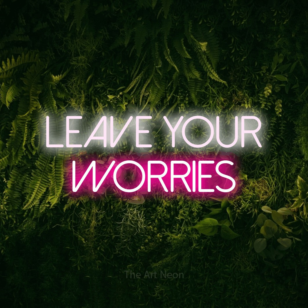 Hot pink and cool white LED neon sign reading "Leave Your Worries" against a moss-covered green wall for hotel décor