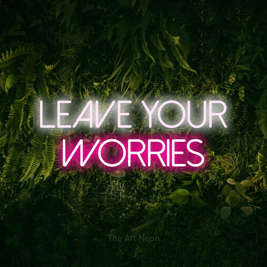 Hot pink and cool white LED neon sign reading "Leave Your Worries" against a moss-covered green wall for hotel décor