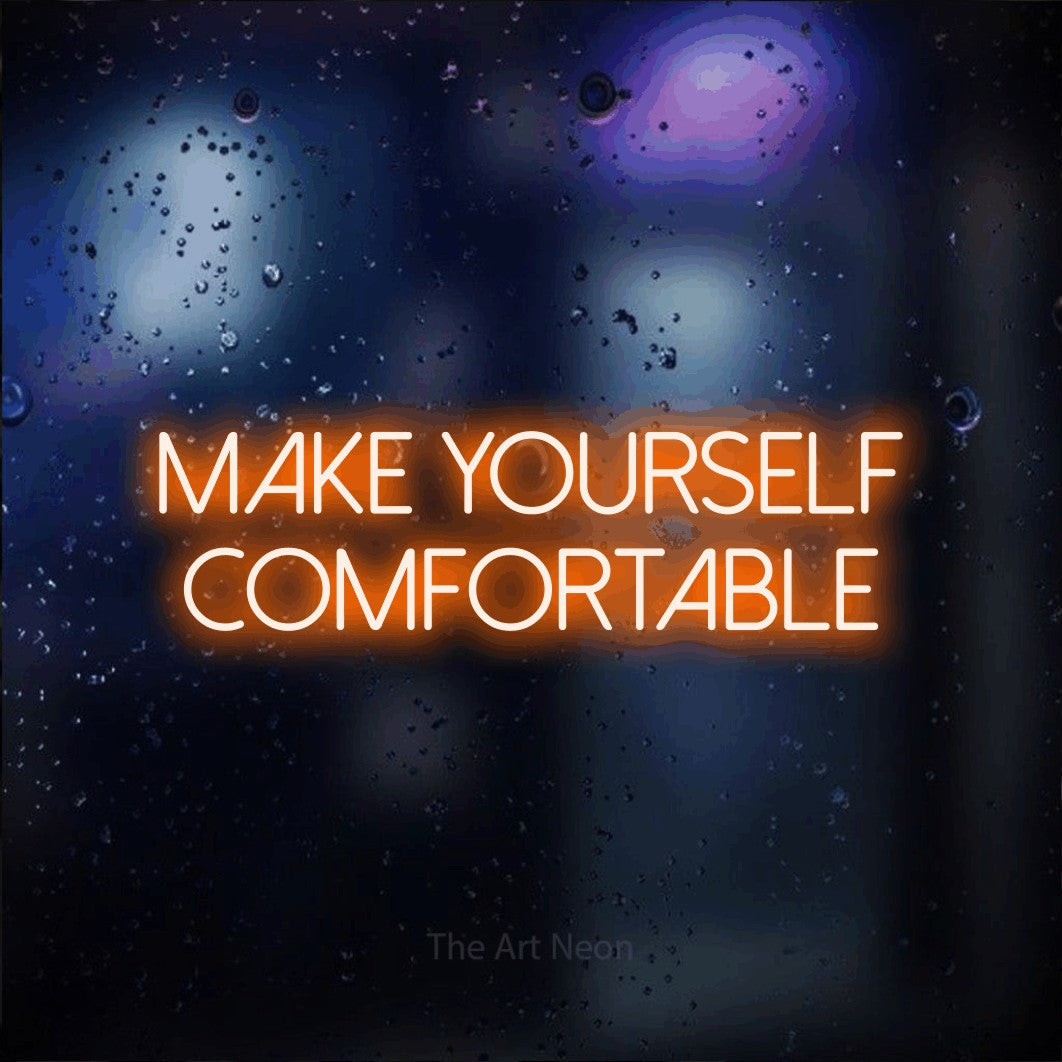 Orange LED neon sign reading "Make Yourself Comfortable" against a dark blue bokeh background for hotel décor