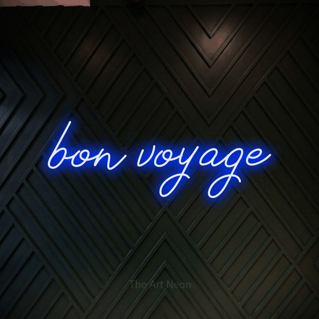 Blue script-style LED neon sign reading "Bon Voyage" against a dark geometric wood wall for hotel décor