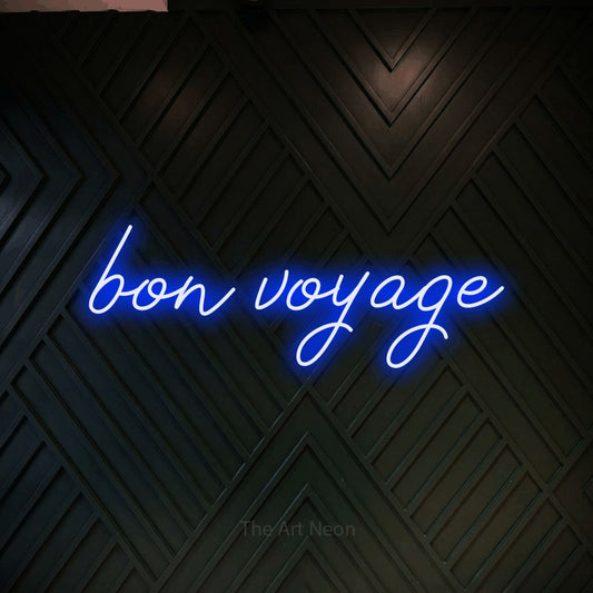 Blue script-style LED neon sign reading "Bon Voyage" against a dark geometric wood wall for hotel décor