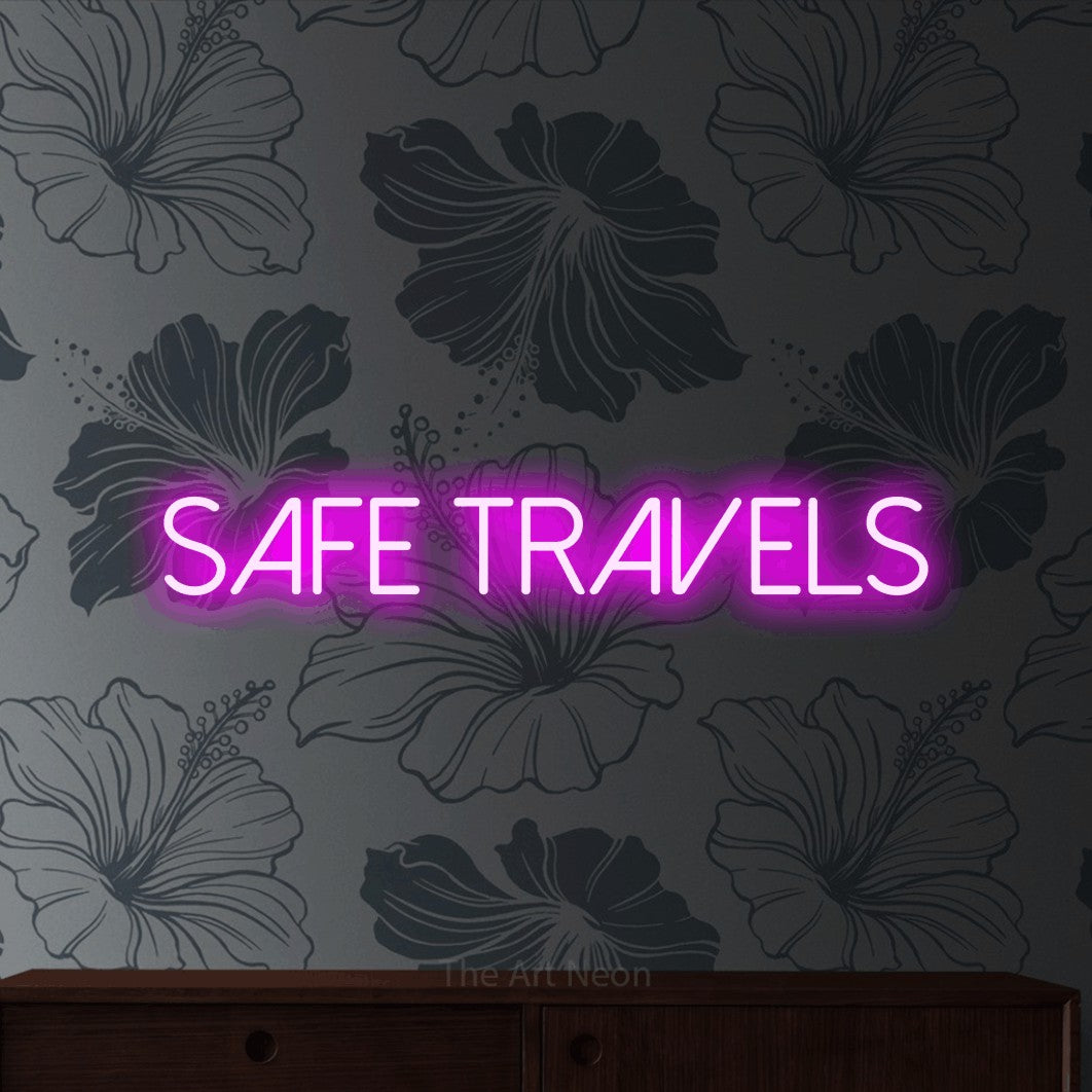 Pink LED neon sign reading "Safe Travels" against grey floral wallpaper for hotel décor
