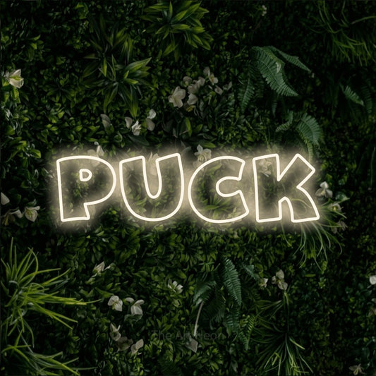 Enseigne néon à DEL à lumière blanche chaude, de style contour, affichant « Puck » sur un mur de feuillage vert