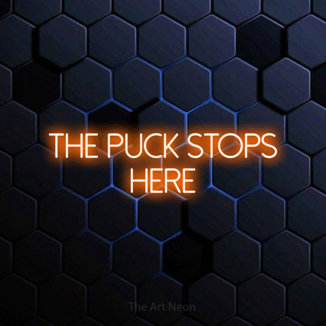Orange LED neon sign reading "The Puck Stops Here" against a blue hexagonal wall