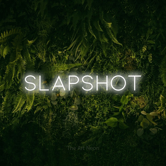 Cool white LED neon sign reading "Slapshot" against a moss-covered green wall