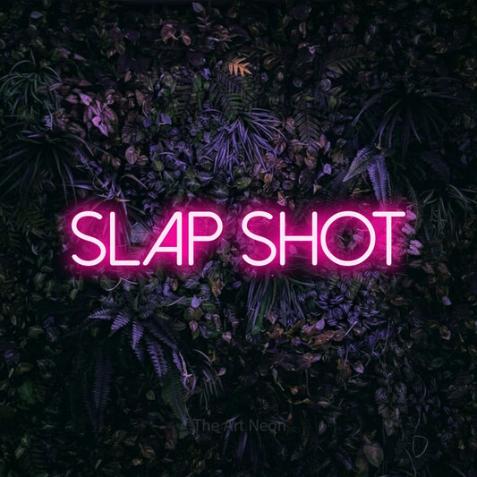 Hot pink LED neon sign reading "Slap Shot" against a purple floral wall