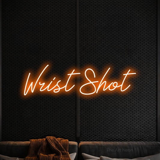 Orange script-style LED neon sign reading "Wrist Shot" against a black textured wall