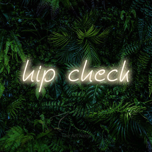 Warm white LED neon sign reading "Hip Check" against a dense tropical foliage wall