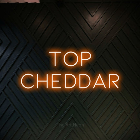 Orange LED neon sign reading "Top Cheddar" against a dark geometric wood wall