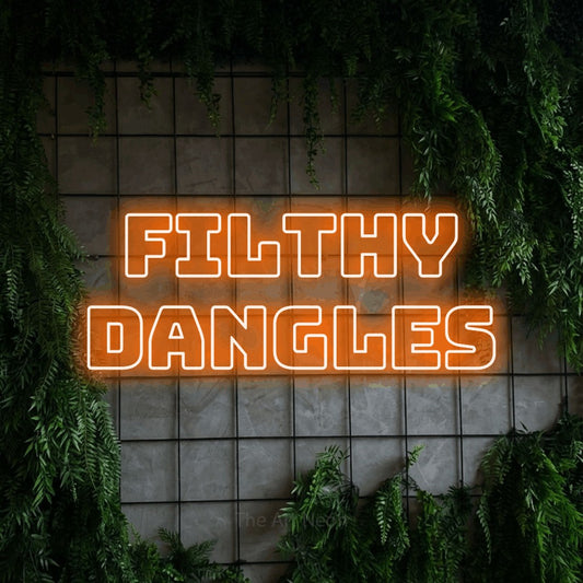 Orange outline-style LED neon sign reading "Filthy Dangles" against a green grid wall with foliage
