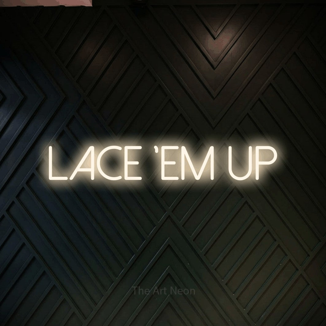 Warm white LED neon sign reading "Lace 'Em Up" against a dark geometric wood wall