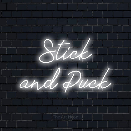 Cool white script-style LED neon sign reading "Stick and Puck" against a dark navy brick wall
