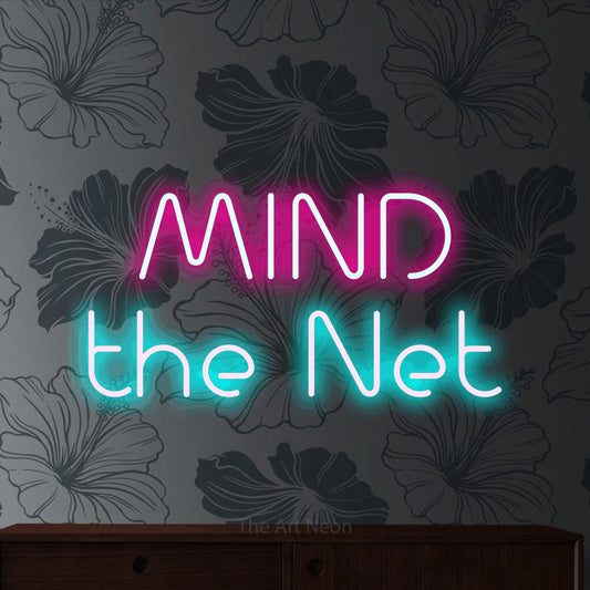 Ice blue and hot pink LED neon sign reading "Mind the Net" against grey floral wallpaper