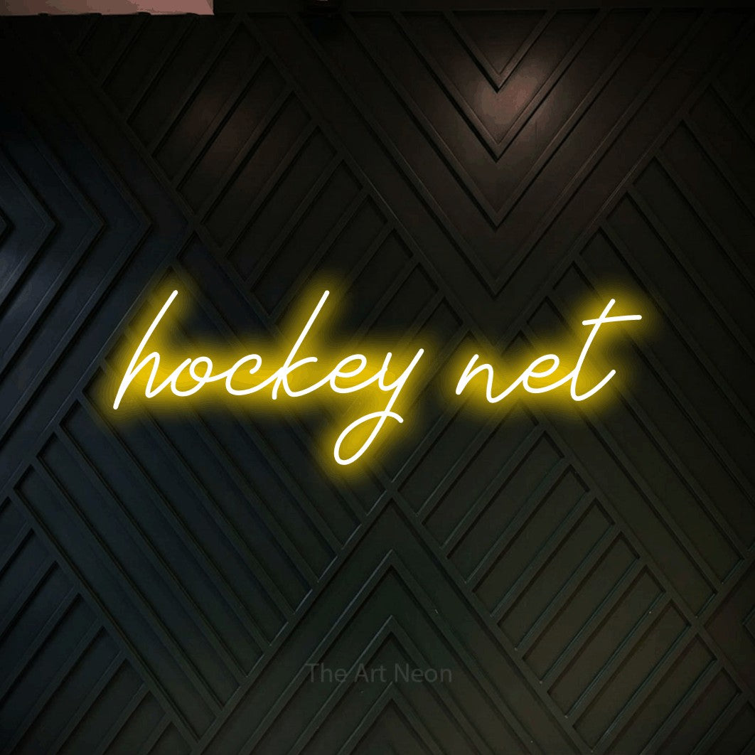 Yellow script-style LED neon sign reading "Hockey Net" against a dark geometric wood wall