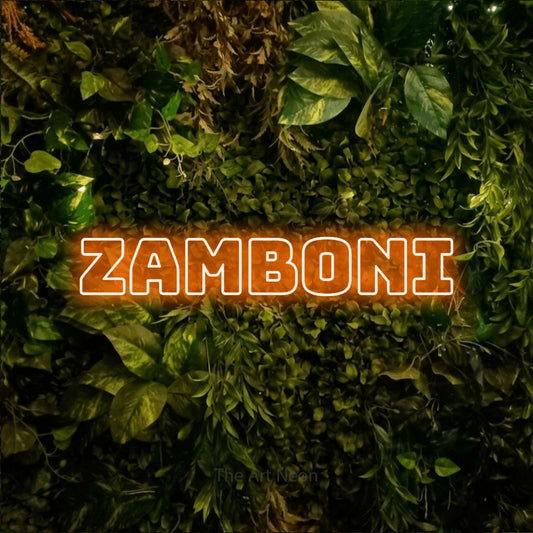 Enseigne néon à DEL à lumière orange, de style contour, affichant « Zamboni » sur un mur texturé de mousse et de feuillage