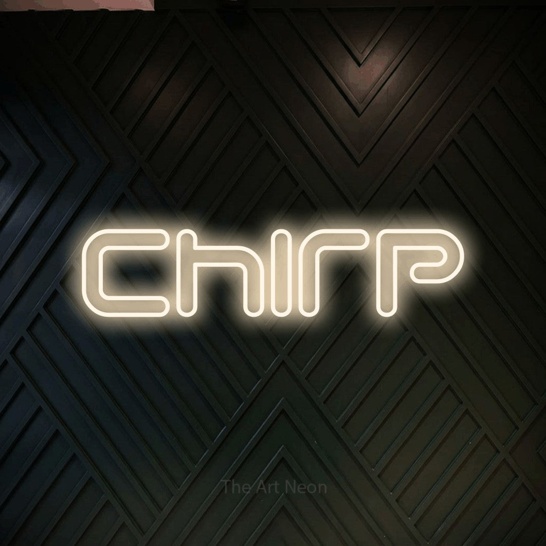 Warm white outline-style LED neon sign reading "Chirp" against a dark geometric wood wall