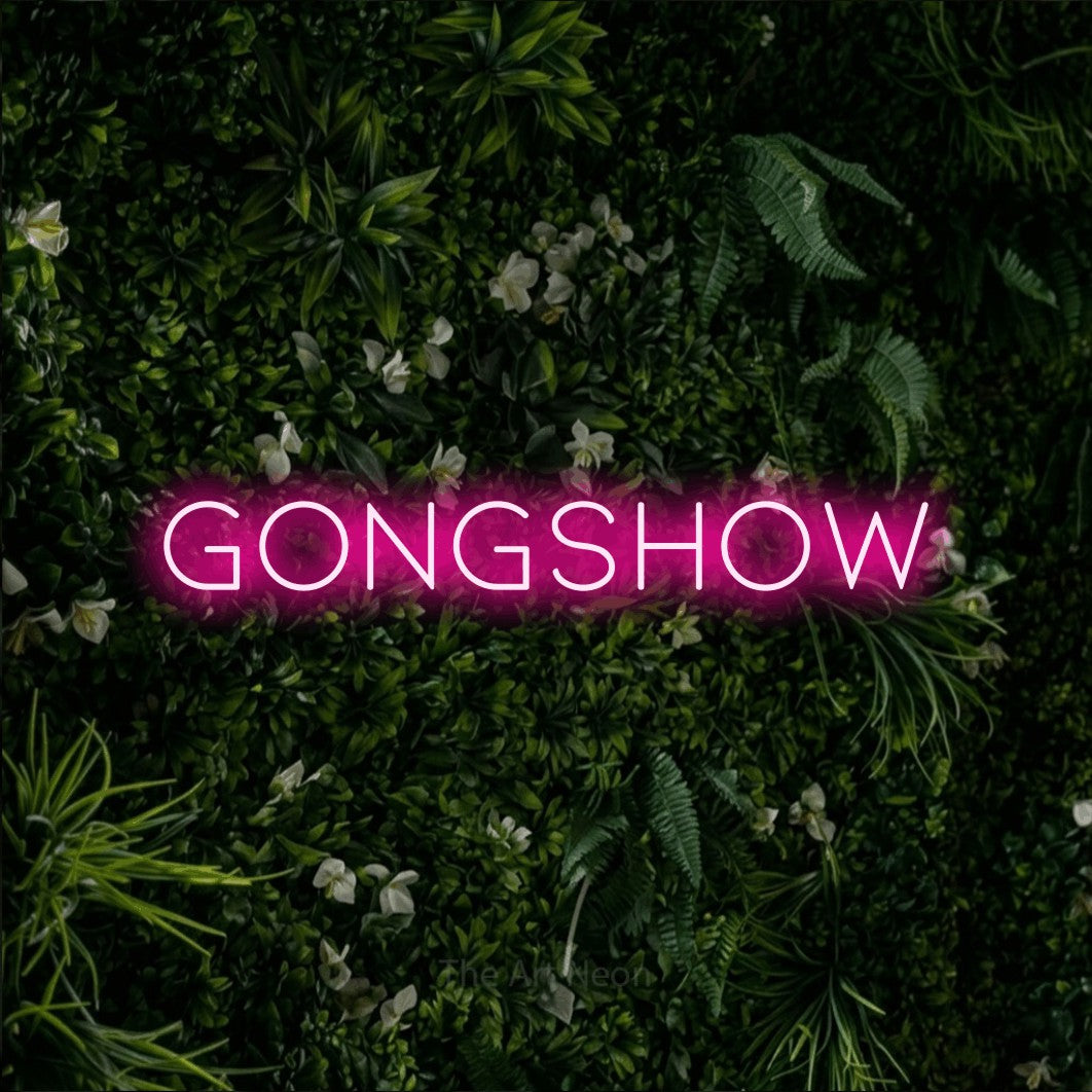 Hot pink LED neon sign reading "Gongshow" against a leafy green wall