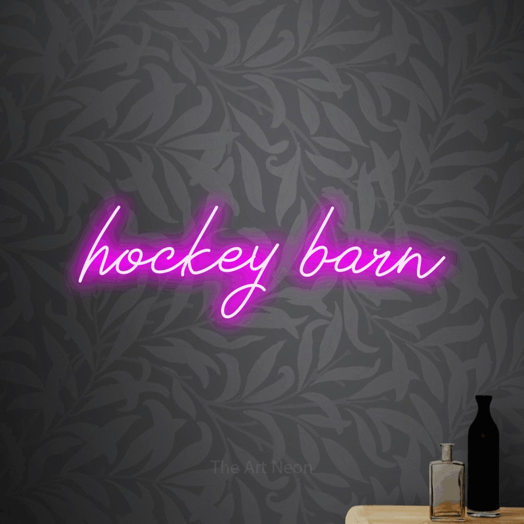 Pink script-style LED neon sign reading "Hockey Barn" against light grey floral wallpaper