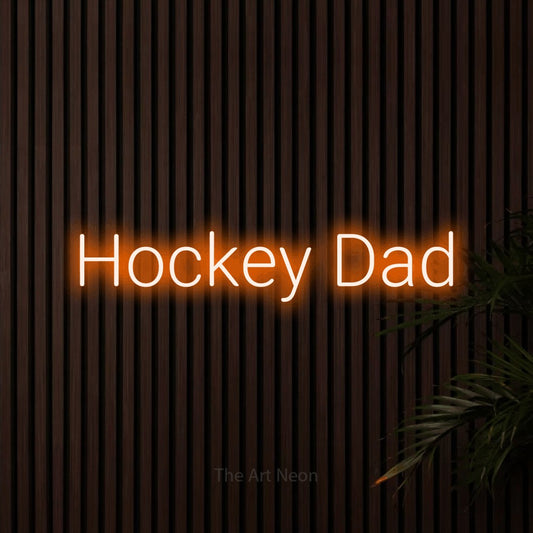 Orange LED neon sign reading "Hockey Dad" against dark wooden slats