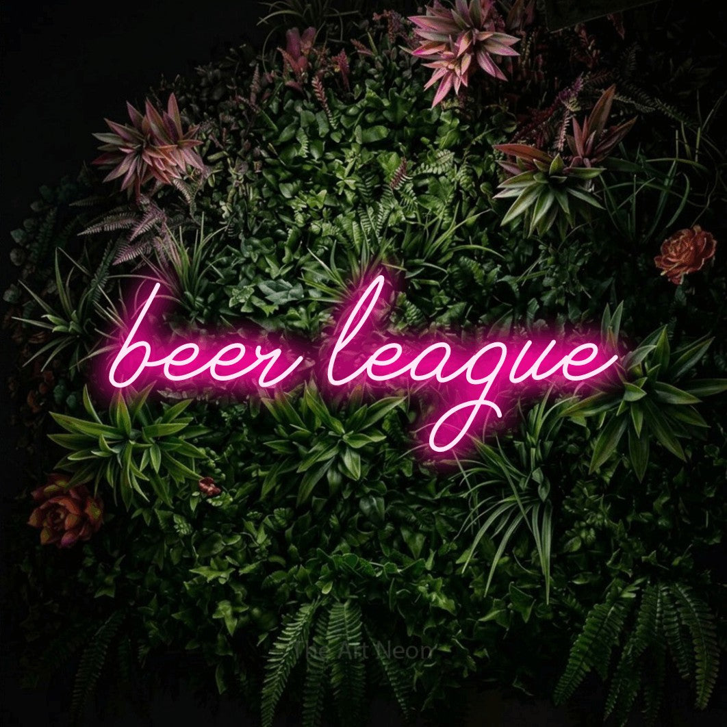 Hot pink script-style LED neon sign reading "Beer League" against a flowering garden wall