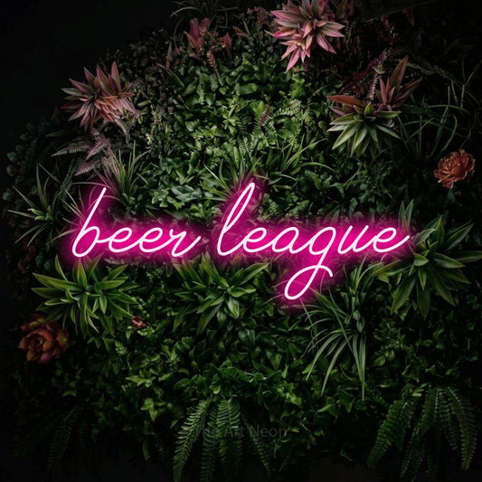 Hot pink script-style LED neon sign reading "Beer League" against a flowering garden wall
