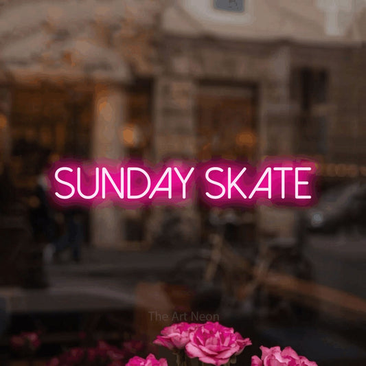 Hot pink LED neon sign reading "Sunday Skate" in a softly blurred café interior