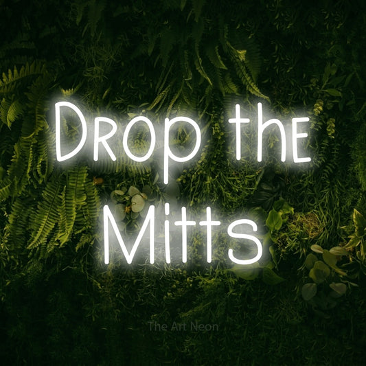 Cool white LED neon sign reading "Drop the Mitts" against a moss-covered green wall