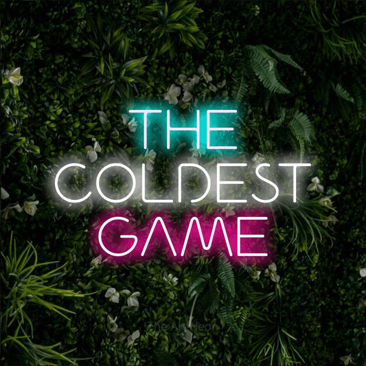 Multicolour LED neon sign reading "The Coldest Game" against a leafy green wall