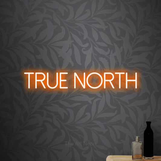 Orange LED neon sign reading "True North" against light grey floral wallpaper