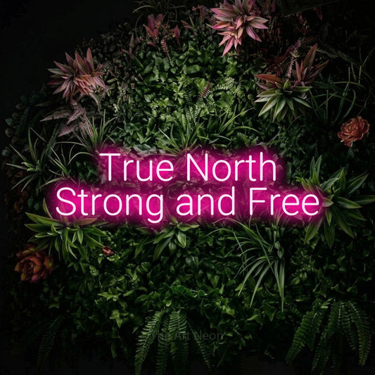 Hot pink LED neon sign reading "True North Strong and Free" against a flowering garden wall