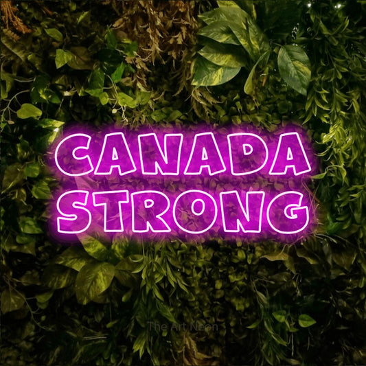 Pink outline-style LED neon sign reading "Canada Strong" against a textured moss and foliage wall