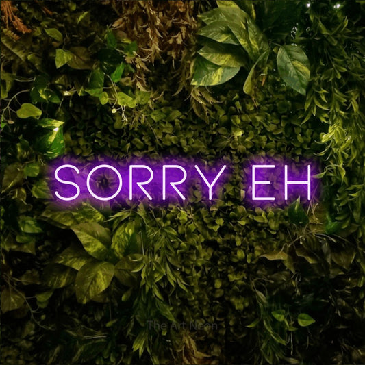 Purple LED neon sign reading "Sorry Eh" against a textured moss and foliage wall