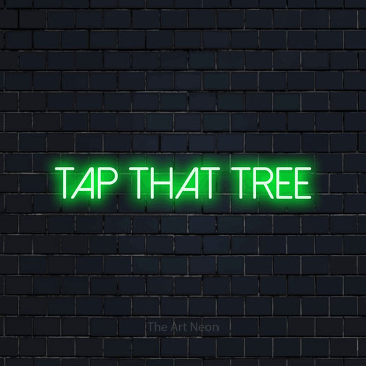 Enseigne néon à DEL à lumière verte, affichant « Tap That Tree » sur un mur de briques bleu marine foncé