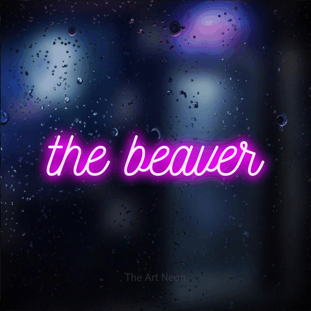 Pink script-style LED neon sign reading "The Beaver" against a dark blue bokeh background