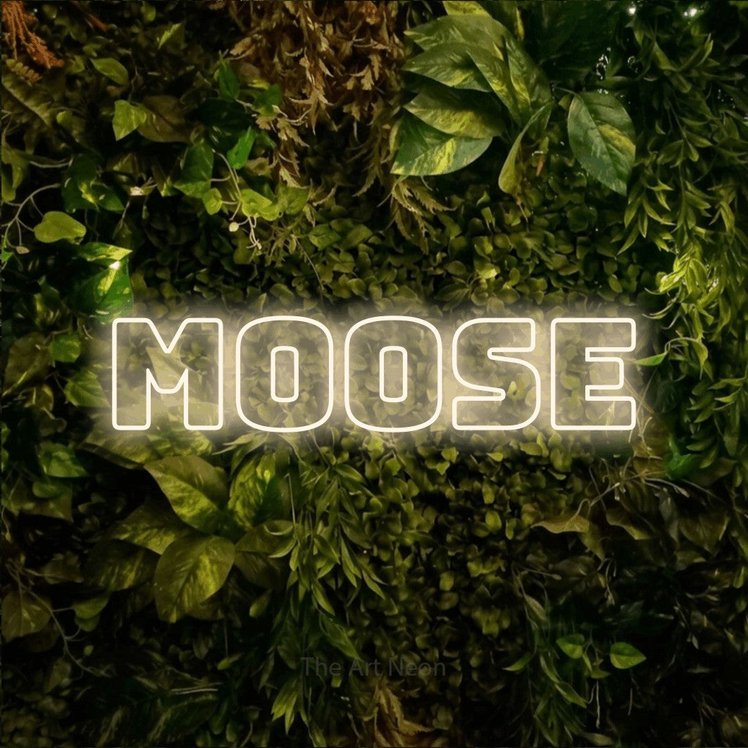 Warm white outline-style LED neon sign reading "Moose" against a textured moss and foliage wall