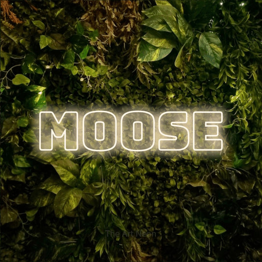 Enseigne néon à DEL à lumière blanche chaude, de style contour, affichant « Moose » sur un mur texturé de mousse et de feuillage