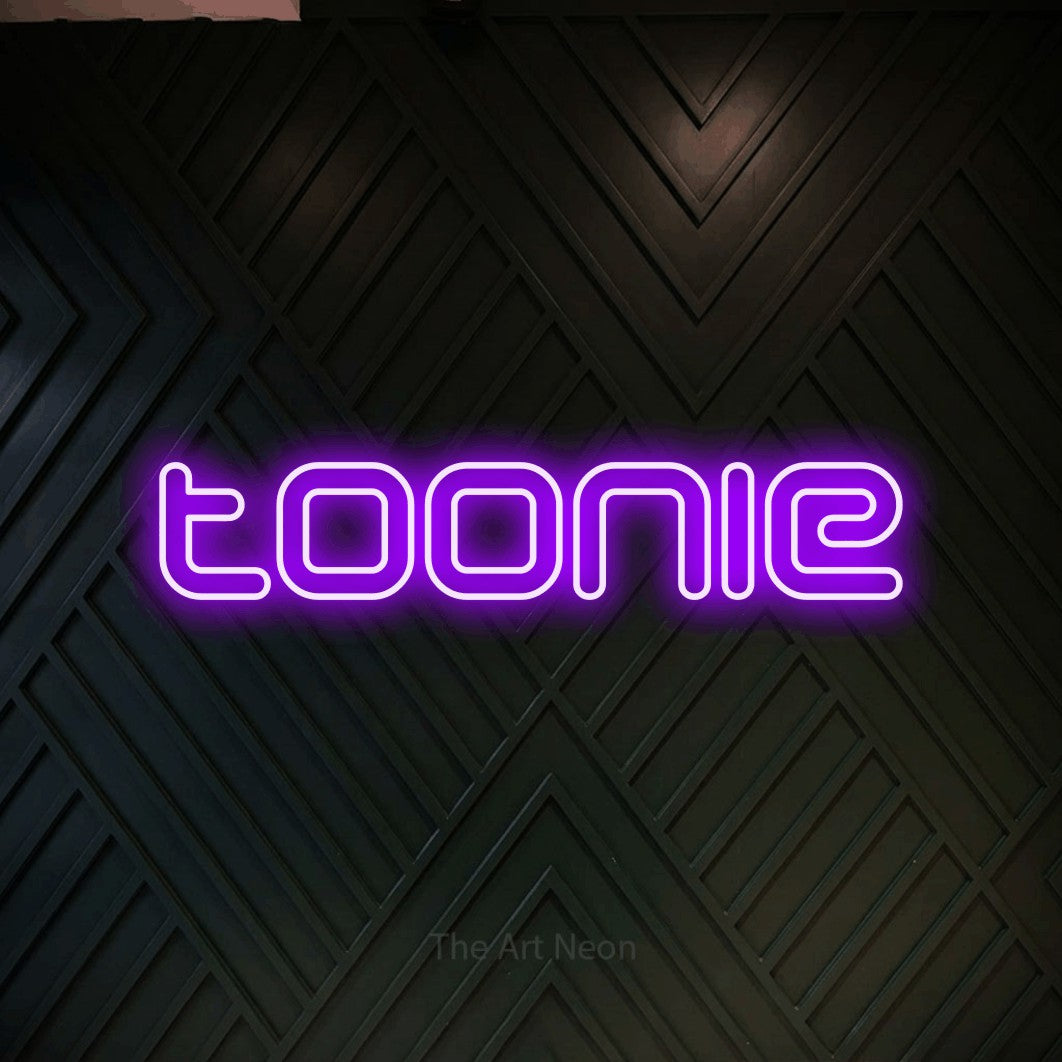 Enseigne néon à DEL à lumière violette, de style contour, affichant « Toonie » sur un mur géométrique en bois foncé