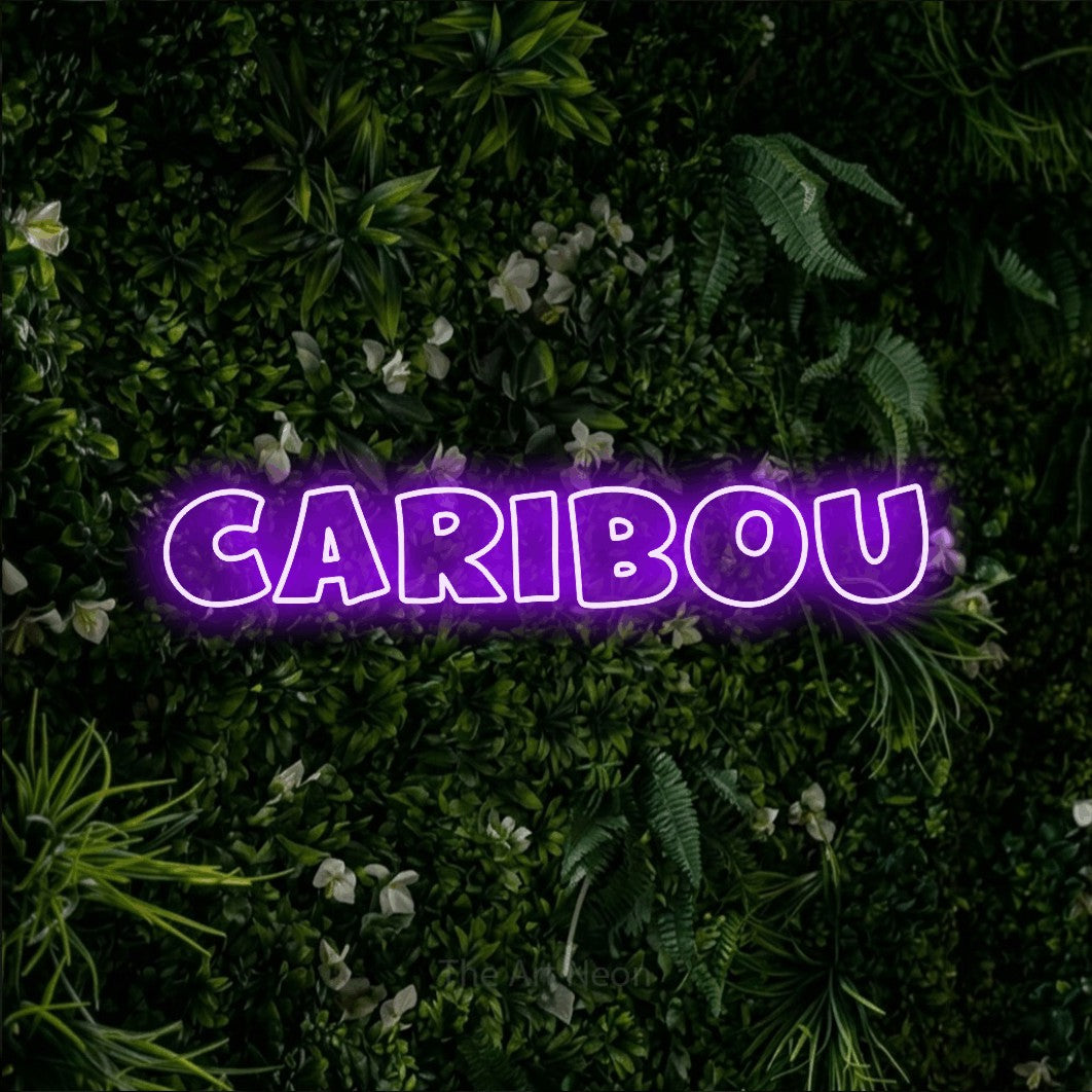 Enseigne néon à DEL à lumière violette, de style contour, affichant « Caribou » sur un mur de feuillage vert