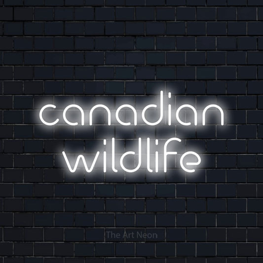 Enseigne néon à DEL à lumière blanche froide, affichant « Canadian Wildlife » sur un mur de briques bleu marine foncé