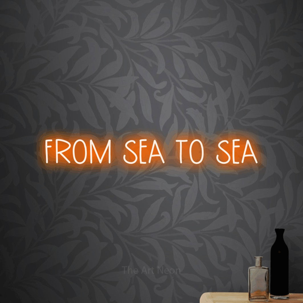 Orange LED neon sign reading "From Sea to Sea" against light grey floral wallpaper