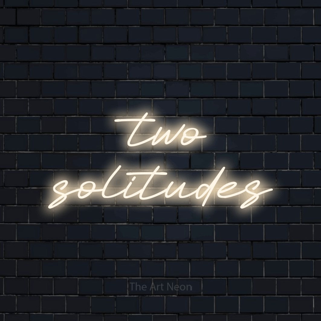 Warm white LED neon sign reading "Two Solitudes" against a dark navy brick wall