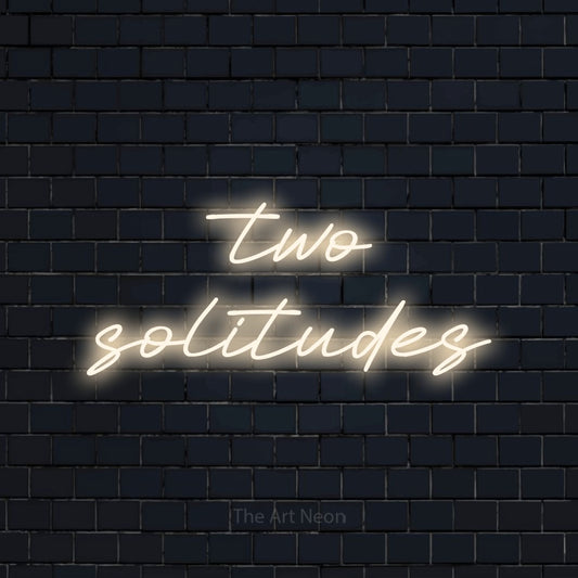 Warm white LED neon sign reading "Two Solitudes" against a dark navy brick wall