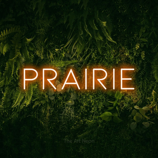 Orange LED neon sign reading "Prairie" against a moss-covered green wall