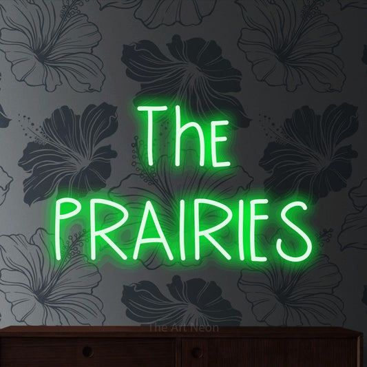 Green LED neon sign reading "The Prairies" against grey floral wallpaper