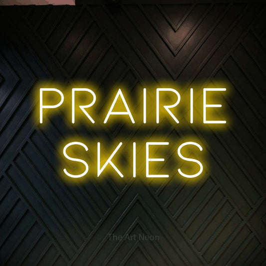 Yellow LED neon sign reading "Prairie Skies" against a dark geometric wood wall