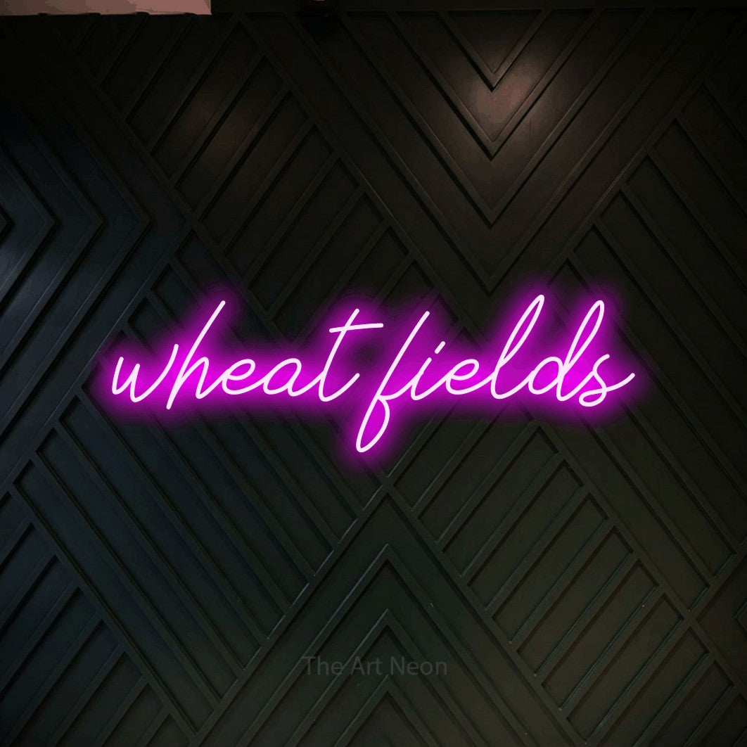 Pink script-style LED neon sign reading "Wheat Fields" against a dark geometric wood wall